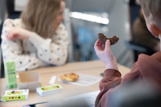 Barn håller i fikabröd på tåget