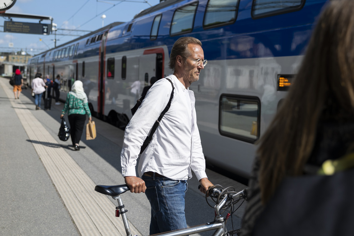 man som ska gå ombord på tåget med sin cykel